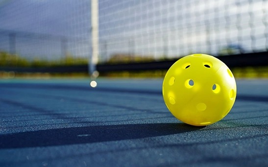 Pickleball ball with holes designed for outdoor and indoor gameplay